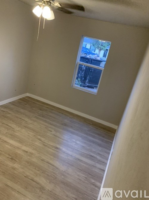 A room with a window and a ceiling fan.