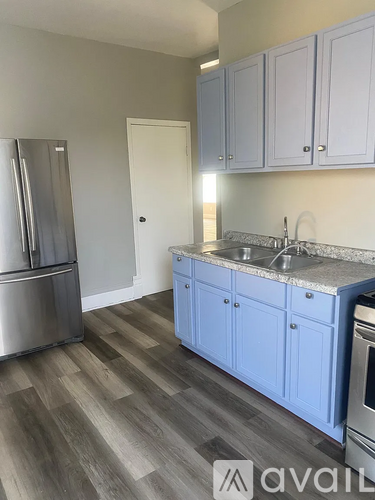 A white bathroom with a towel bar and a shower door.