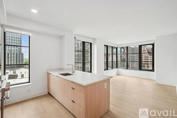 A kitchen with wooden cabinets and a large window overlooking a cityscape.