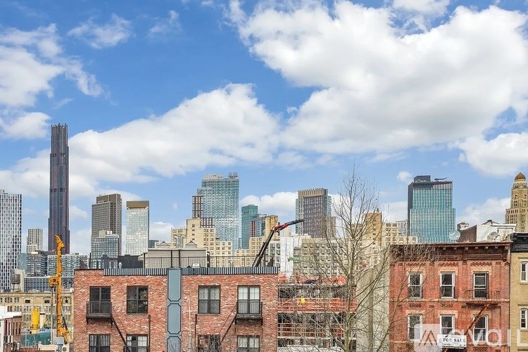 A cityscape with a mix of modern and older buildings under a partly cloudy sky.