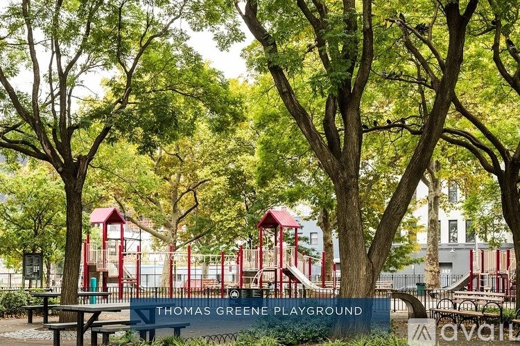 A playground with a red slide and a sign that says Thomas Green Playground.