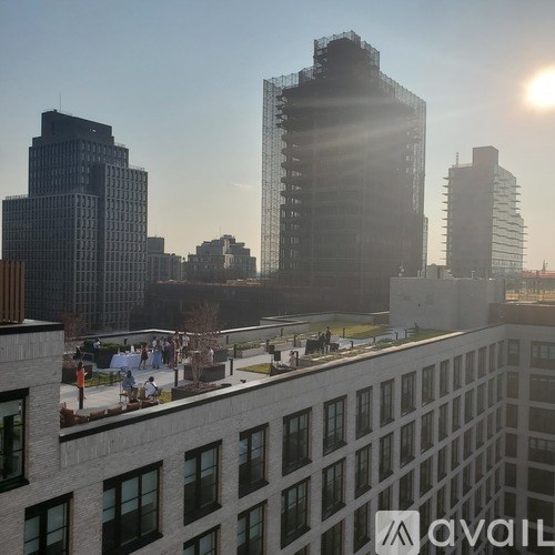A sunny day in a city with tall buildings and people enjoying the outdoors.