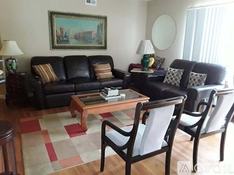 A living room with a black couch and a coffee table.