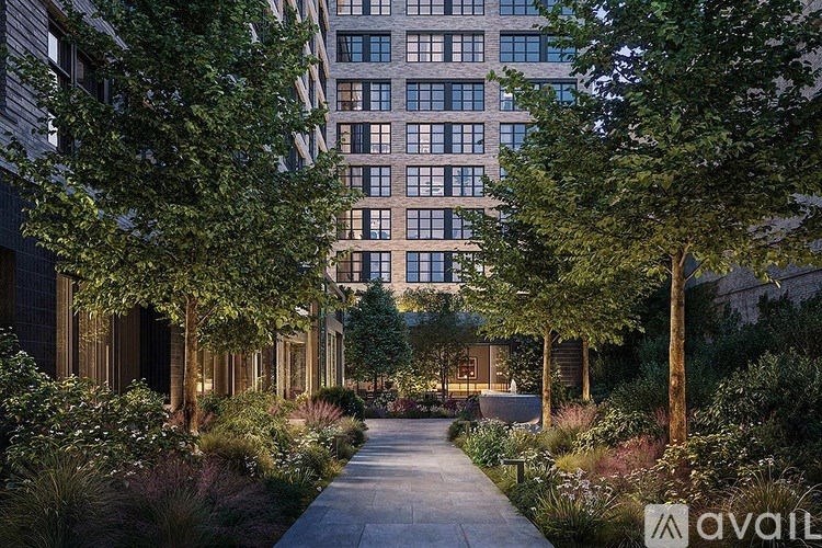A pathway leads through a landscaped courtyard between two buildings.