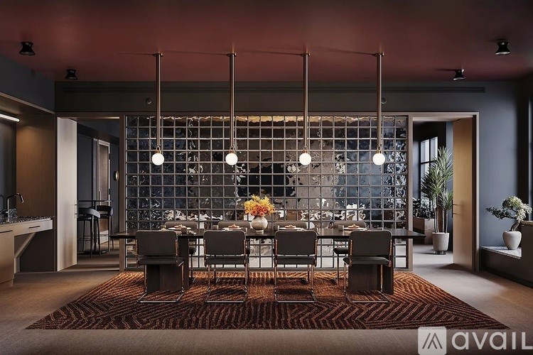 A modern dining room with a glass partition wall and a long table set for a meal.