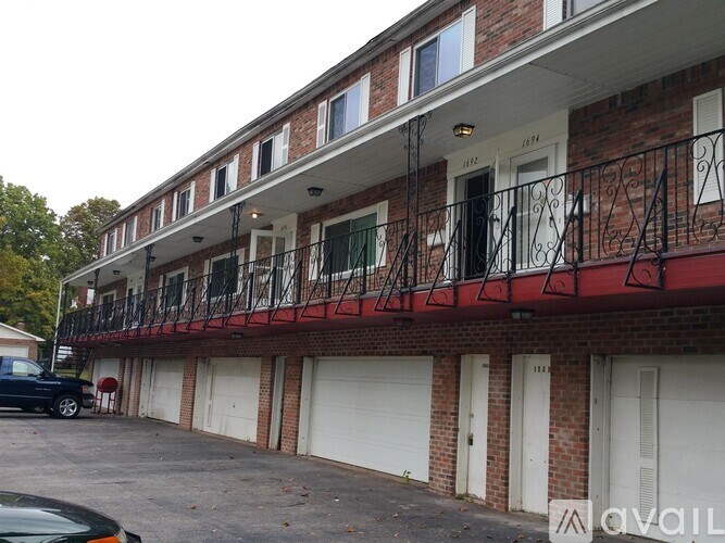 A red brick building with a black car parked in front.