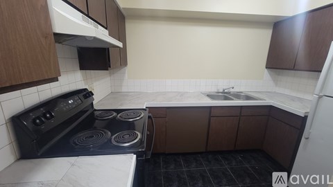 A kitchen with a black stove top oven and a white microwave above it.