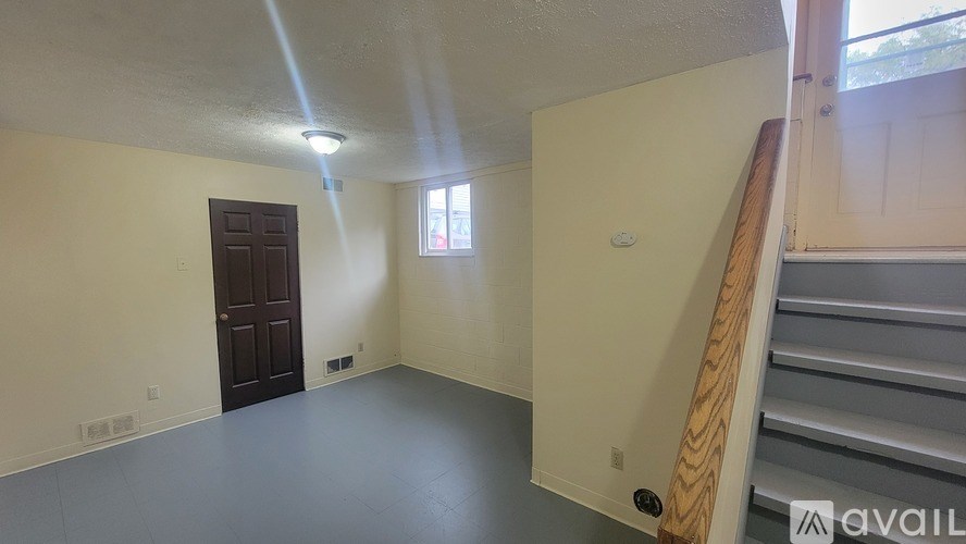 A room with a brown door and a window on the wall.