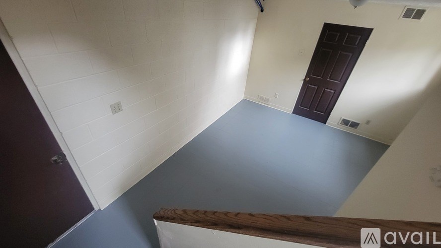 A room with a wooden staircase leading to the second floor.