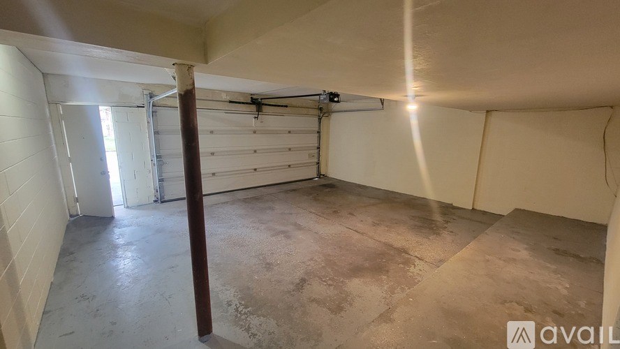 A spacious garage with a white door and a concrete floor.