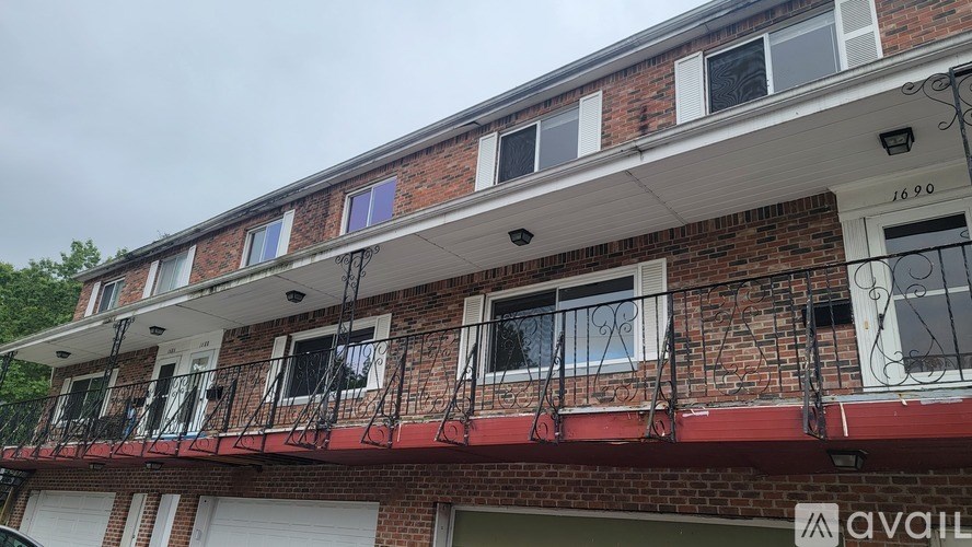 A red brick building with a balcony and a sign that says "available".