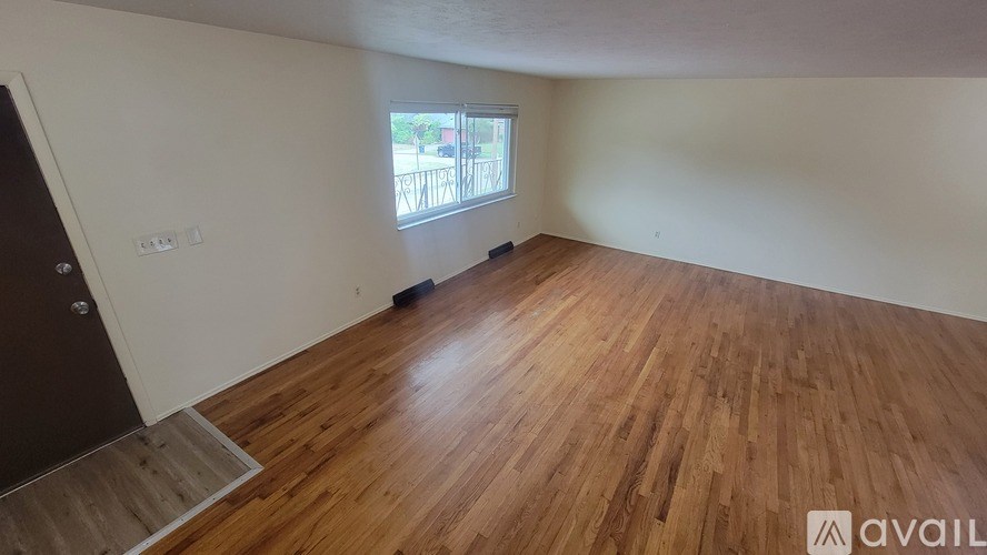 A room with wooden flooring and a window.