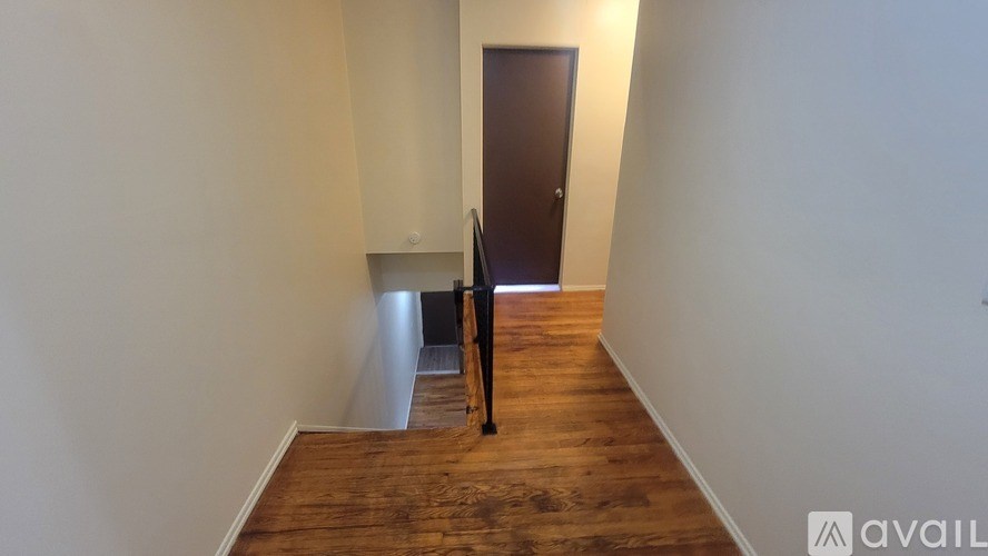 A room with a wooden floor and a brown door.