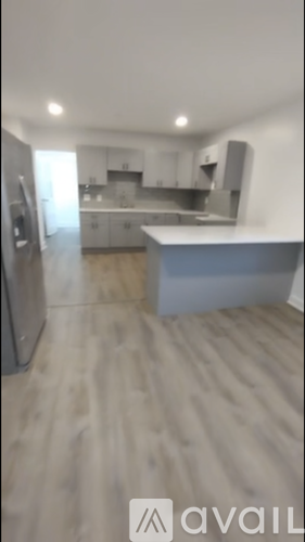 A kitchen with a refrigerator, sink, and countertop.
