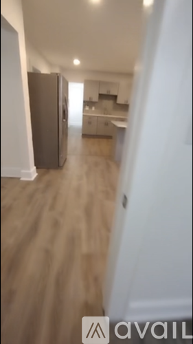 A long hallway with a kitchen in the distance.
