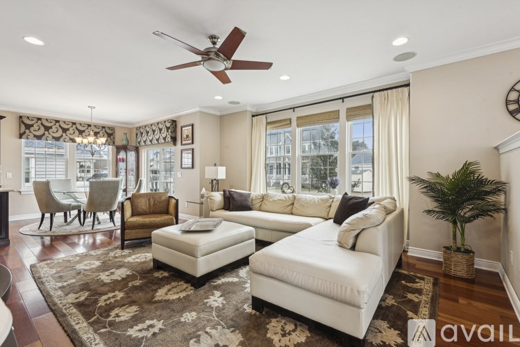 A living room with a white couch, a rug, and a ceiling fan.