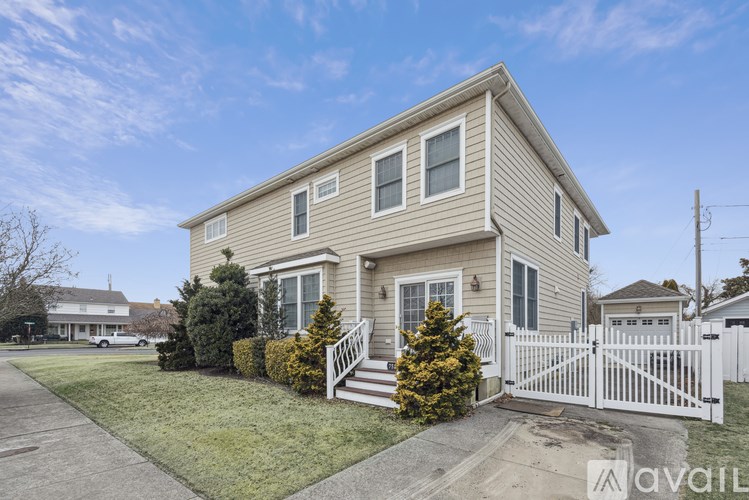 A two-story house with a white picket fence in front.