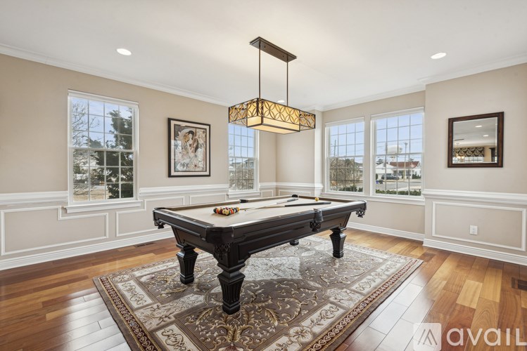 A pool table in a room with a large window.