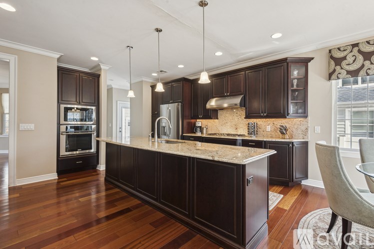 A modern kitchen with dark wood cabinets and a granite countertop.