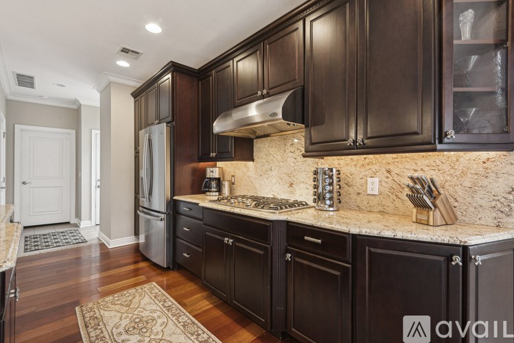 A kitchen with dark wood cabinets and a granite countertop.