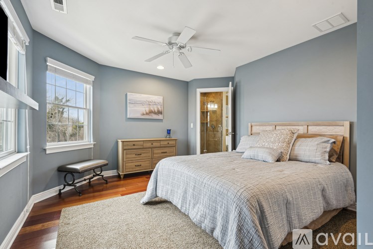 A bedroom with a bed, dresser, and window.