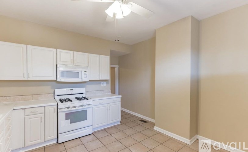 A kitchen with white appliances and cabinets.