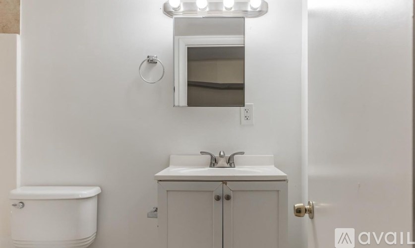 A white bathroom with a toilet, sink, and medicine cabinet.