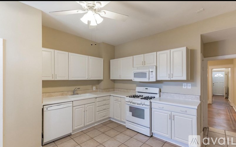 A kitchen with white appliances and cabinets.