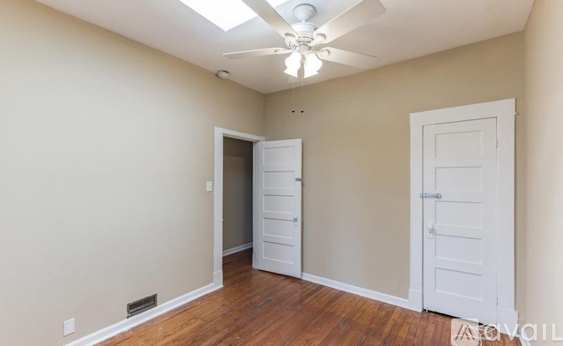 A room with a ceiling fan and two doors.