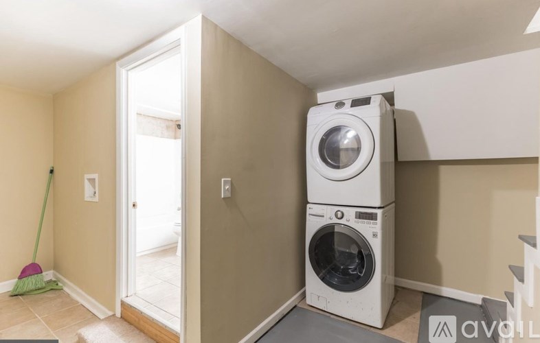 A white front loading washing machine in a laundry room.