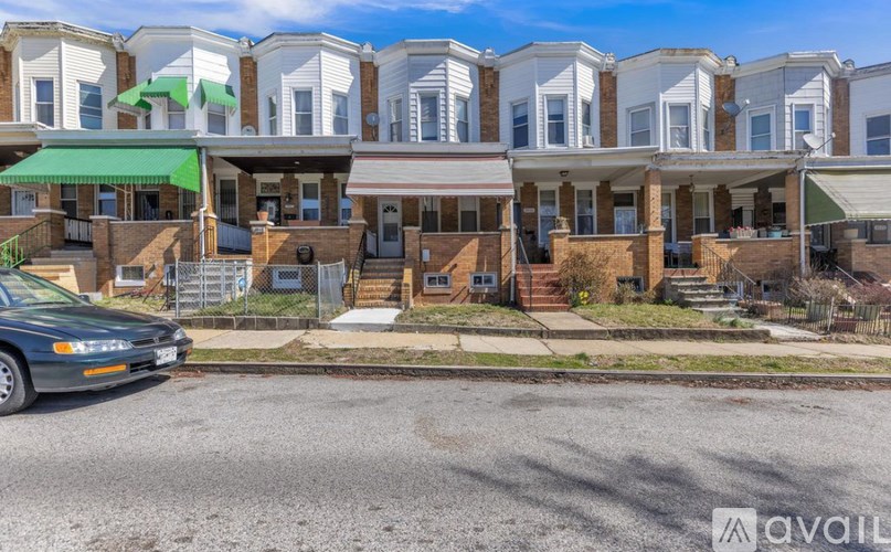 A row of townhouses with a car parked in front.