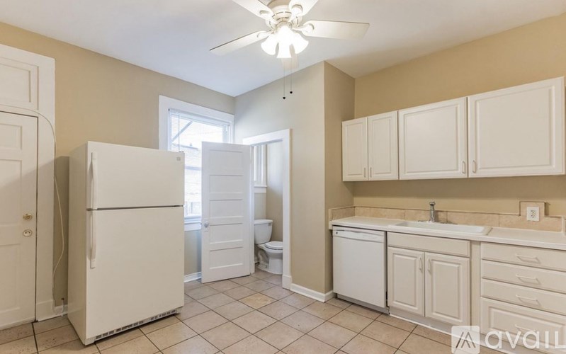 A kitchen with a white refrigerator and cabinets.