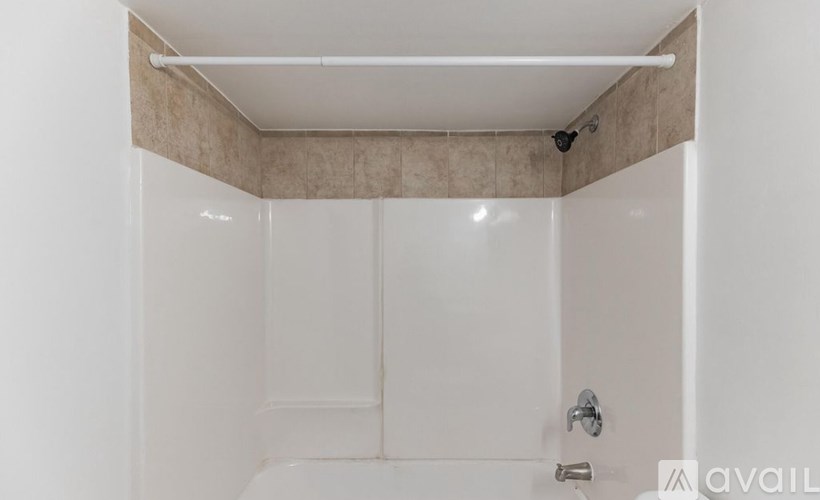 A white bathroom with a shower stall and a door.