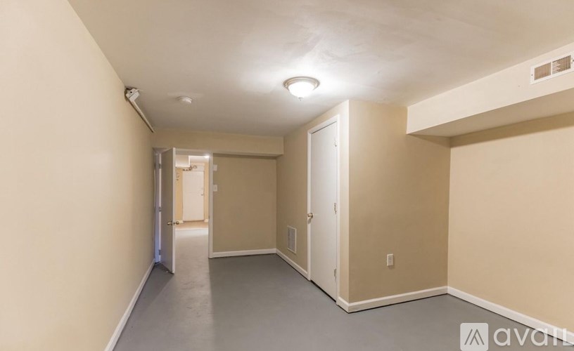 A long, empty hallway with a door at the end.