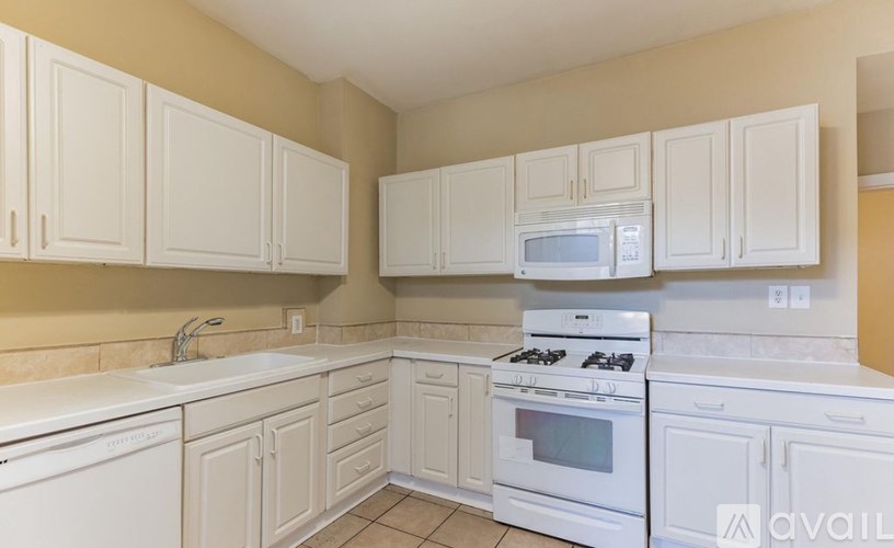 A kitchen with white appliances and cabinets.