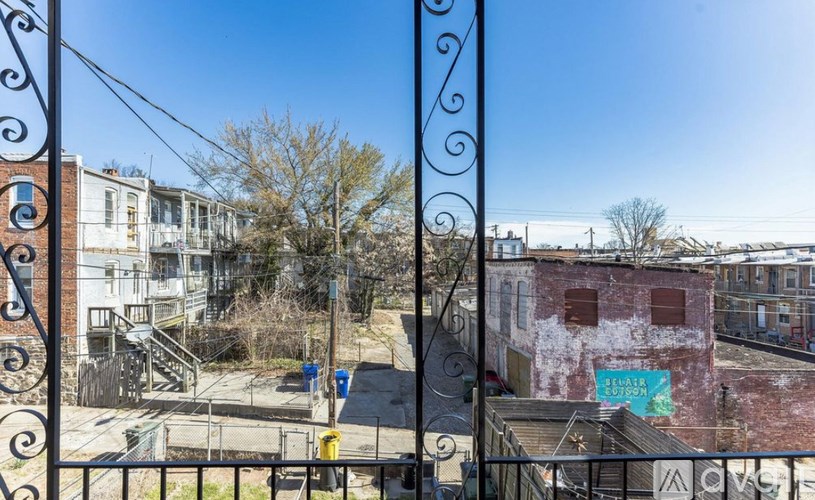 A view of a cityscape through a wrought iron fence.