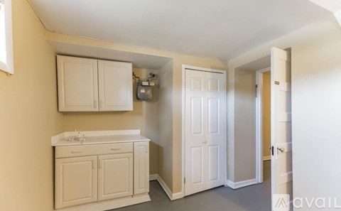 A kitchen with white cabinets and a white sink.