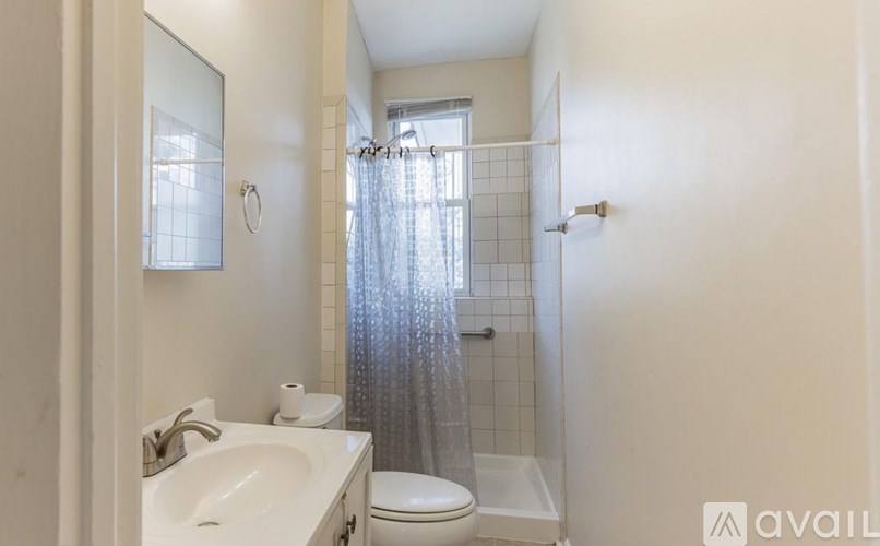 A bathroom with a white sink, toilet, and shower curtain.