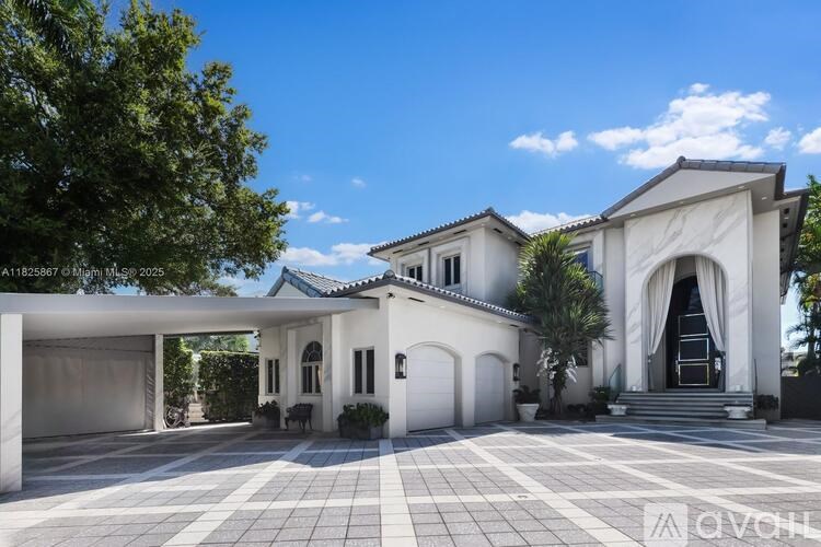 A large white house with a tiled driveway and a covered patio area.