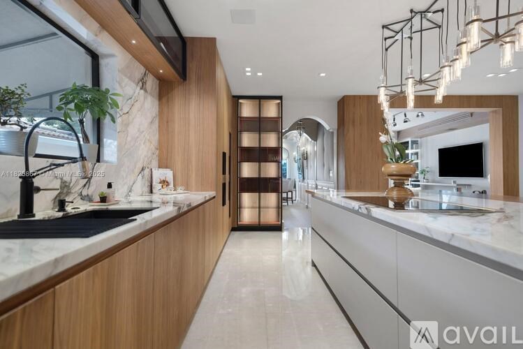 A modern kitchen with a marble countertop and wooden cabinets.
