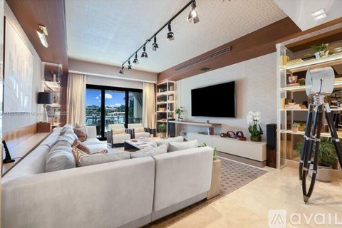 A modern living room with a large couch and a television.