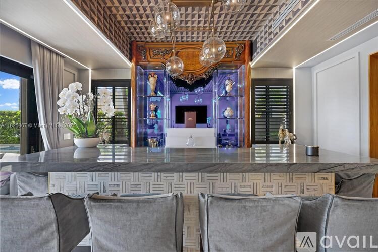 A dining room with a marble table and grey chairs.