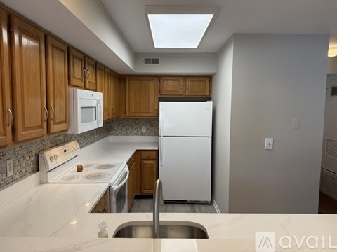 A kitchen with wooden cabinets and a white refrigerator.
