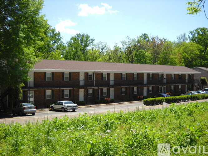 A building with a brown roof and a parking lot in front of it.