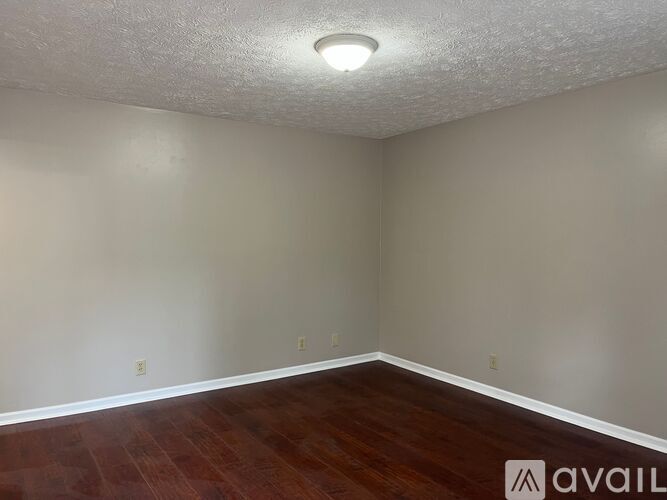 A room with a white door and wooden floor.