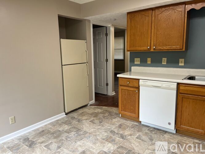 A kitchen with wooden cabinets and white appliances.