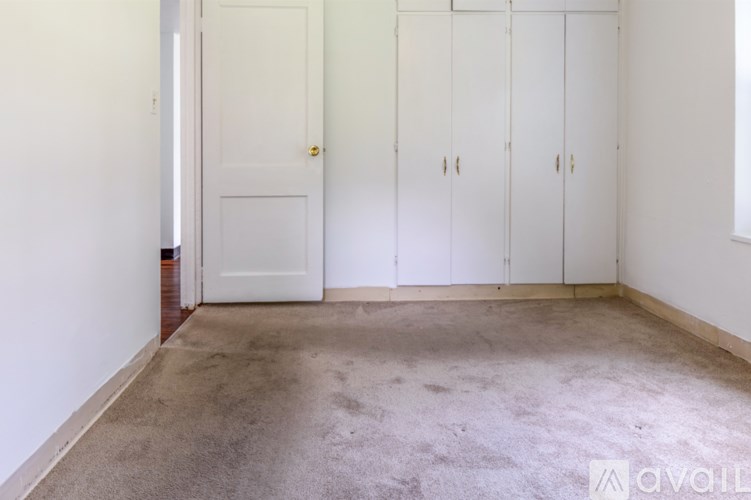 A room with a white door and three white cupboards.
