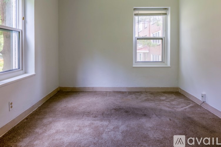 A room with a carpeted floor and a window.