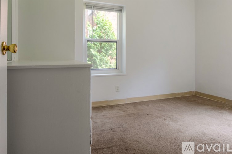 A room with a carpeted floor and a window.