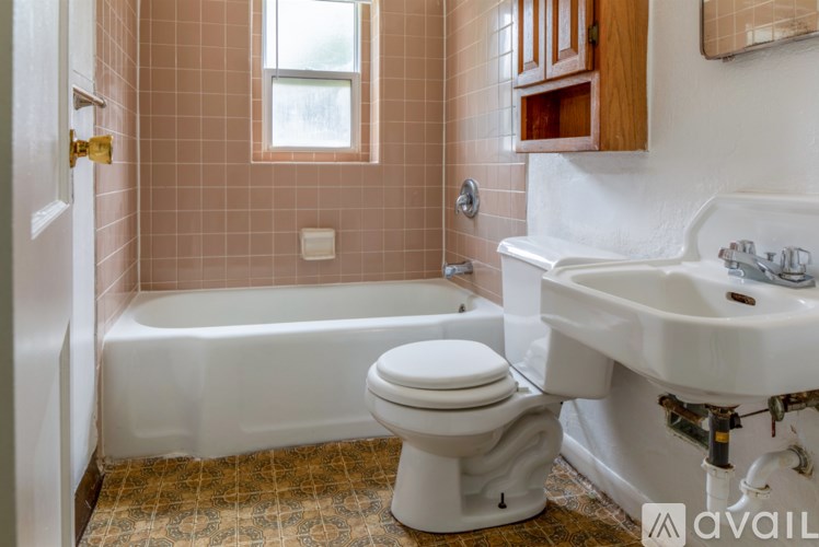 A bathroom with a toilet, sink, and bathtub.